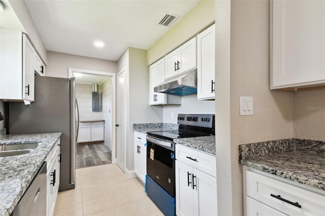 2902 Wheeler St, Bartow, FL 33830 - kitchen with stainless steel appliances, under cabinet range hood, white cabinetry, light stone countertops, and light tile patterned floors