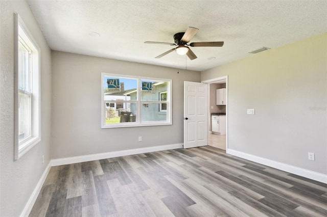 2902 Wheeler St, Bartow, FL 33830 - unfurnished bedroom featuring wood finished floors, multiple windows, a textured ceiling, and ceiling fan