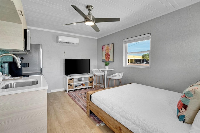 122 Coral Ave, Redington Shores, FL 33708 - bedroom featuring a wall unit AC, light wood finished floors, a ceiling fan, and a textured wall