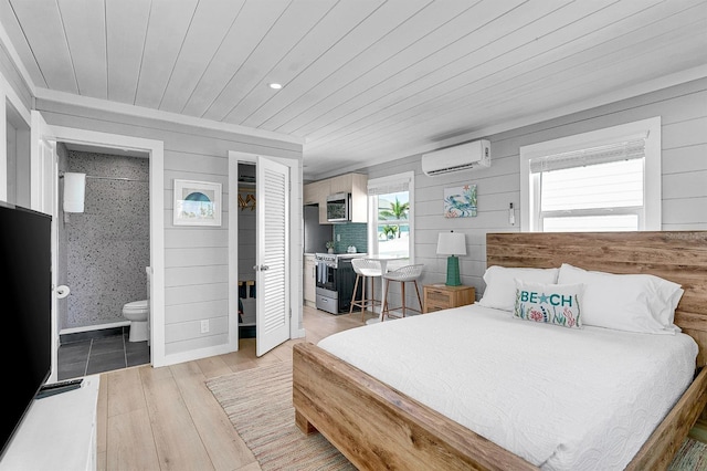 122 Coral Ave, Redington Shores, FL 33708 - bedroom with a wall unit AC, light wood finished floors, wood ceiling, and connected bathroom