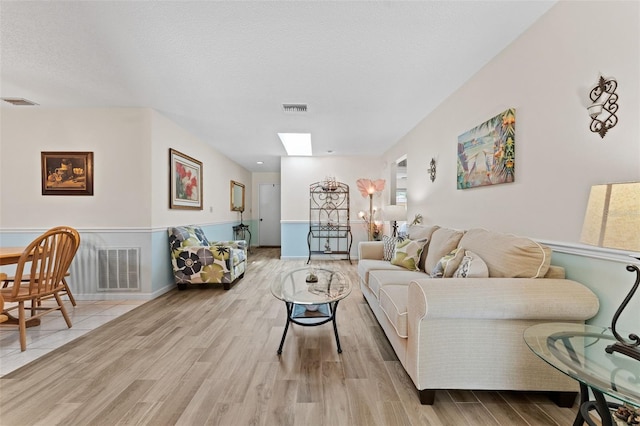 6289 107th Ave N, Pinellas Park, FL 33782 - living room featuring wood finished floors, a skylight, and a textured ceiling