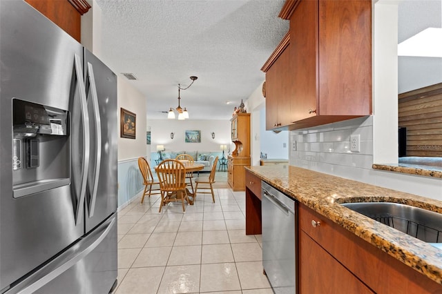 6289 107th Ave N, Pinellas Park, FL 33782 - kitchen featuring stainless steel appliances, brown cabinets, light tile patterned flooring, light stone counters, and tasteful backsplash