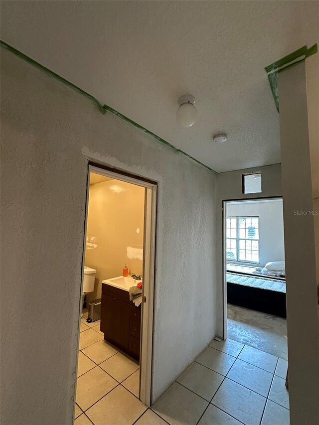 120 Henry St, Interlachen, FL 32148 - corridor featuring a textured wall, light tile patterned flooring, and a textured ceiling