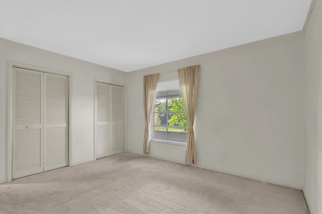 8451 Candlewood Rd Unit 8451, Seminole, FL 33777 - unfurnished bedroom with multiple closets and light colored carpet
