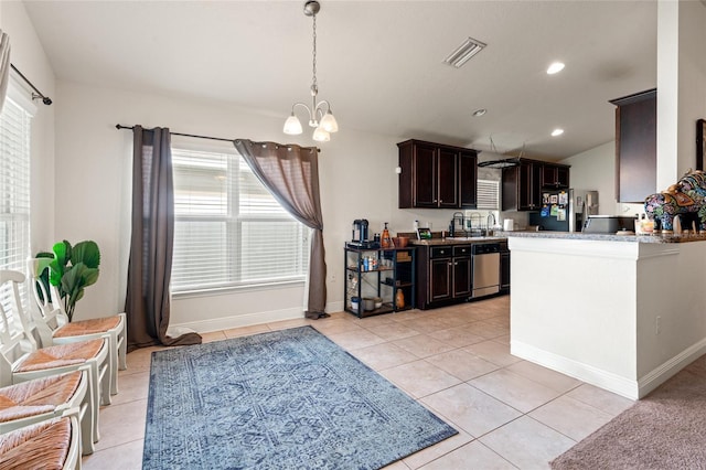 10909 Kirkwall Port Dr, Wimauma, FL 33598 - kitchen featuring appliances with stainless steel finishes, dark brown cabinets, light tile patterned floors, a chandelier, and decorative light fixtures