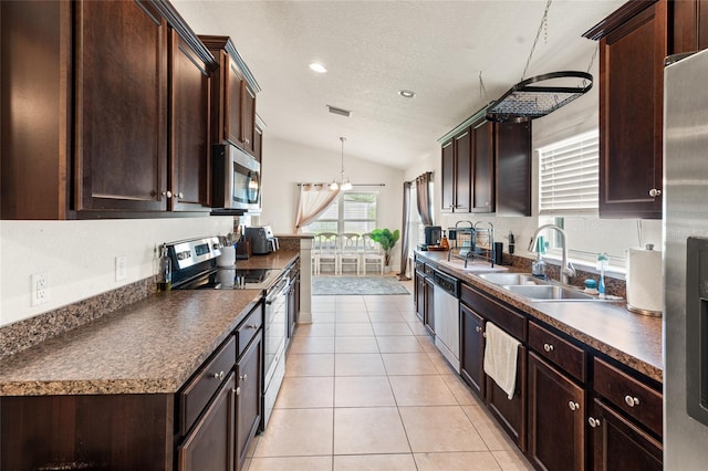 10909 Kirkwall Port Dr, Wimauma, FL 33598 - kitchen featuring stainless steel appliances, lofted ceiling, dark countertops, light tile patterned flooring, and dark brown cabinetry