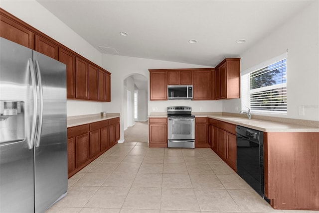 1280 Hill Flower Dr, Brooksville, FL 34604 - kitchen featuring stainless steel appliances, arched walkways, lofted ceiling, light countertops, and light tile patterned floors