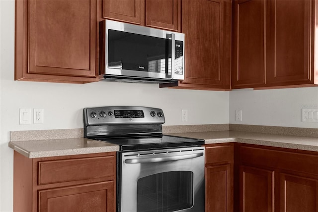 1280 Hill Flower Dr, Brooksville, FL 34604 - kitchen featuring appliances with stainless steel finishes, light countertops, and brown cabinetry