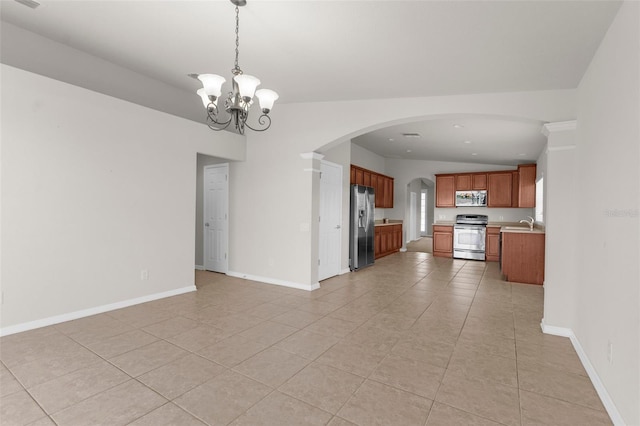 1280 Hill Flower Dr, Brooksville, FL 34604 - kitchen with appliances with stainless steel finishes, open floor plan, arched walkways, light tile patterned floors, and a chandelier