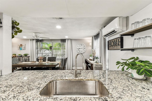 5744 Thrush Dr, New Port Richey, FL 34652 - kitchen with light stone counters, a wall mounted air conditioner, ceiling fan, and recessed lighting