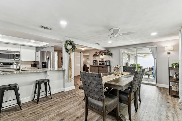 5744 Thrush Dr, New Port Richey, FL 34652 - dining room with a ceiling fan, wood finished floors, recessed lighting, and a raised ceiling