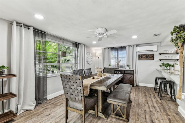 5744 Thrush Dr, New Port Richey, FL 34652 - dining area featuring ceiling fan, wood finished floors, a wall mounted air conditioner, and recessed lighting