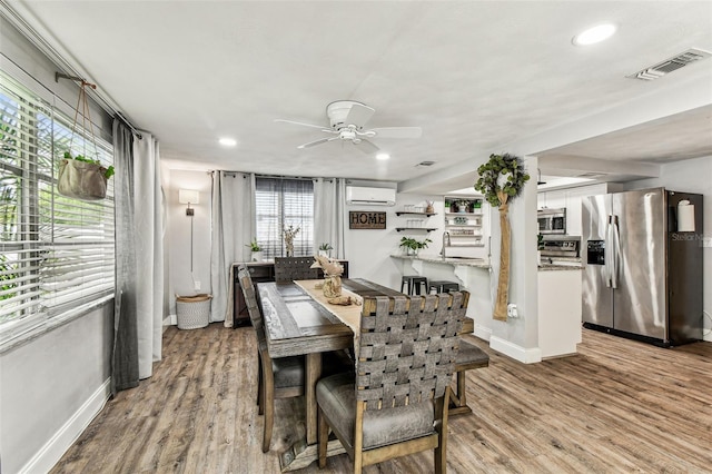 5744 Thrush Dr, New Port Richey, FL 34652 - dining area featuring an AC wall unit, ceiling fan, wood finished floors, and recessed lighting