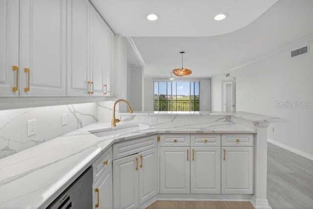 5430 Eagles Point Cir Unit 202, Sarasota, FL 34231 - kitchen featuring a peninsula, light stone counters, white cabinetry, pendant lighting, and dishwasher