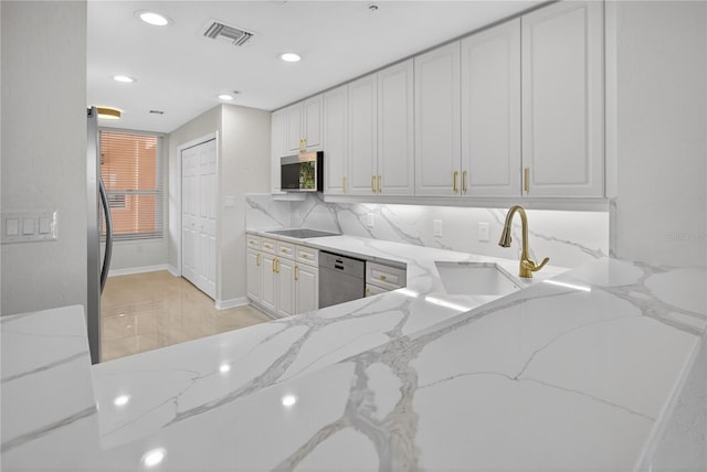 5430 Eagles Point Cir Unit 202, Sarasota, FL 34231 - kitchen featuring appliances with stainless steel finishes, light stone countertops, recessed lighting, white cabinets, and backsplash