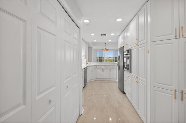 5430 Eagles Point Cir Unit 202, Sarasota, FL 34231 - kitchen with stainless steel appliances, white cabinetry, light countertops, recessed lighting, and light marble finish flooring