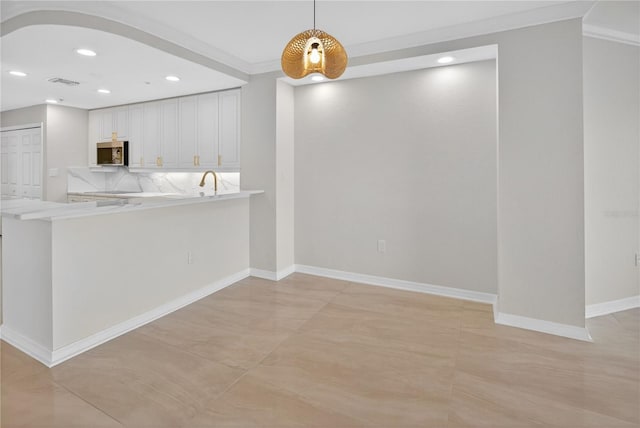 5430 Eagles Point Cir Unit 202, Sarasota, FL 34231 - kitchen with stainless steel microwave, light countertops, decorative light fixtures, white cabinets, and recessed lighting
