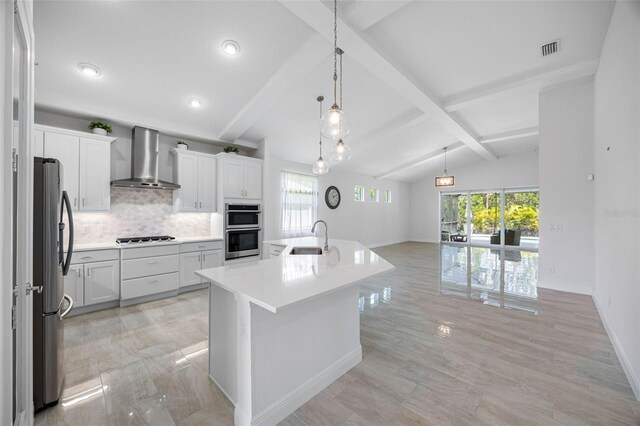 12739 Rainwashed Loop, Parrish, FL 34219 - kitchen featuring wall chimney range hood, stainless steel appliances, tasteful backsplash, light countertops, and a kitchen island with sink