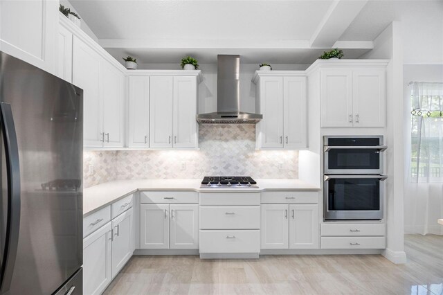 12739 Rainwashed Loop, Parrish, FL 34219 - kitchen featuring stainless steel appliances, wall chimney exhaust hood, light countertops, and white cabinetry