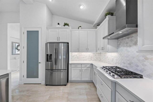 12739 Rainwashed Loop, Parrish, FL 34219 - kitchen with stainless steel appliances, wall chimney exhaust hood, lofted ceiling, decorative backsplash, and light countertops