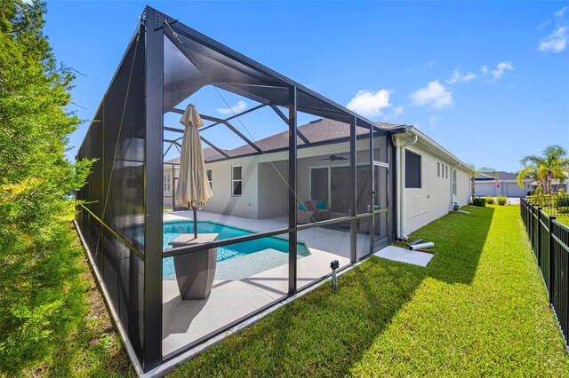 12739 Rainwashed Loop, Parrish, FL 34219 - rear view of house with a patio area, ceiling fan, stucco siding, and glass enclosure
