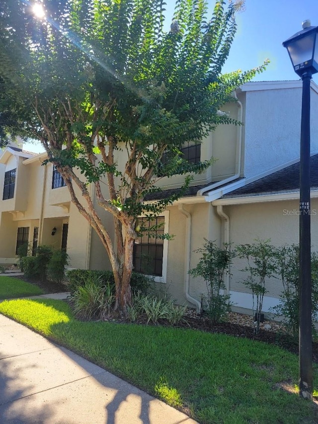 5100 Burchette Rd Unit 1304, Tampa, FL 33647 - view of side of property featuring stucco siding and a lawn