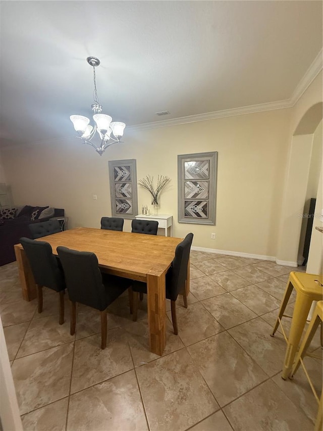 2411 Willimette Dr, Wesley Chapel, FL 33543 - dining space featuring crown molding, arched walkways, a chandelier, and light tile patterned floors
