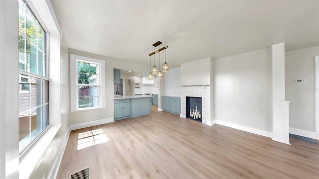 1005 45th St W, Bradenton, FL 34209 - unfurnished living room featuring light wood-type flooring and a fireplace