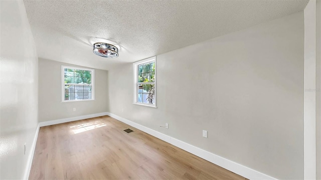 1005 45th St W, Bradenton, FL 34209 - empty room featuring a textured ceiling and light wood-style floors