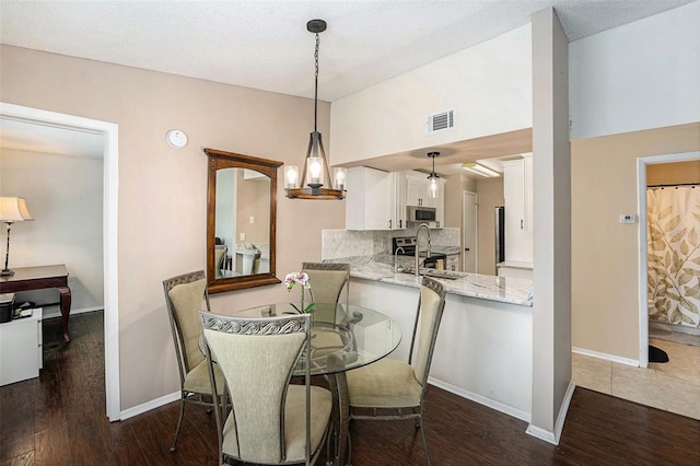 4014 Dream Oak Pl Unit 202, Tampa, FL 33613 - dining room with dark wood-type flooring, vaulted ceiling, and a textured ceiling