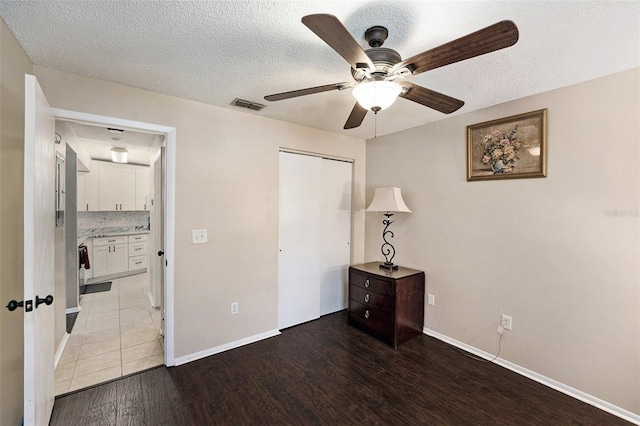 4014 Dream Oak Pl Unit 202, Tampa, FL 33613 - unfurnished bedroom with wood finished floors, a textured ceiling, ceiling fan, and a closet