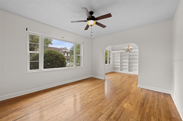 2819 N Central Ave, Tampa, FL 33602 - spare room with a chandelier, light wood-type flooring, arched walkways, a ceiling fan, and built in shelves
