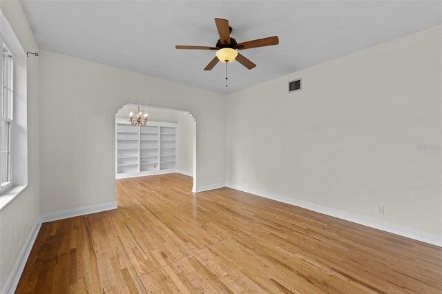 2819 N Central Ave, Tampa, FL 33602 - empty room with a chandelier, light wood-style flooring, a ceiling fan, and built in features