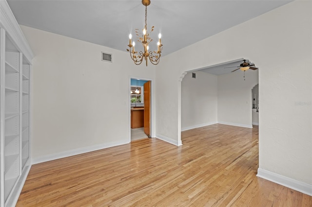 2819 N Central Ave, Tampa, FL 33602 - spare room featuring arched walkways, a chandelier, a ceiling fan, and light wood-type flooring