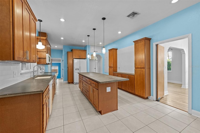 2819 N Central Ave, Tampa, FL 33602 - kitchen with white refrigerator with ice dispenser, dark countertops, brown cabinets, a kitchen island, and recessed lighting