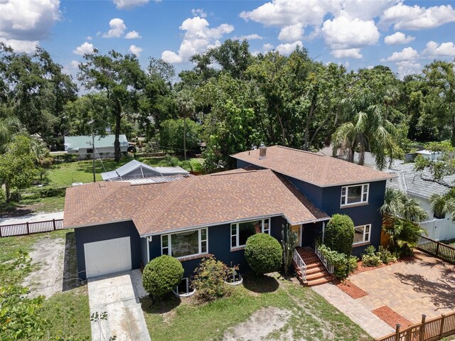 2819 N Central Ave, Tampa, FL 33602 - view of front of house with a garage, concrete driveway, roof with shingles, stucco siding, and view of scattered trees