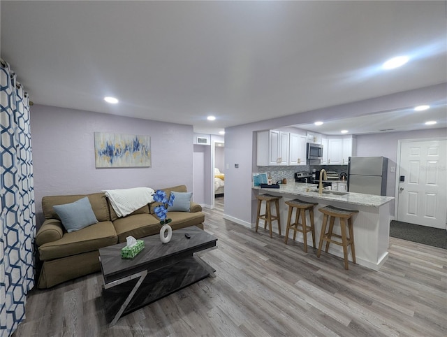 1028 E 93rd Ave Unit A, Tampa, FL 33612 - living room with light wood-style flooring and recessed lighting