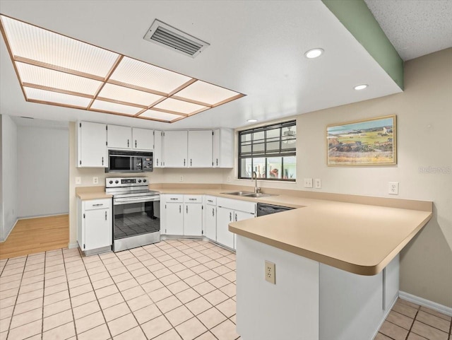 1015 Hastings Ct, Lutz, FL 33548 - kitchen featuring electric stove, black microwave, light countertops, light tile patterned flooring, and a peninsula