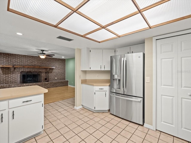 1015 Hastings Ct, Lutz, FL 33548 - kitchen featuring stainless steel refrigerator with ice dispenser, light countertops, light tile patterned flooring, open floor plan, and a fireplace