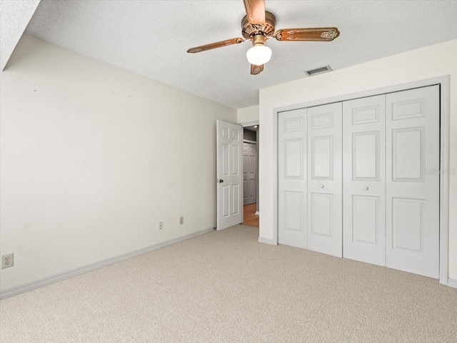 1015 Hastings Ct, Lutz, FL 33548 - unfurnished bedroom with light colored carpet, a textured ceiling, a closet, and a ceiling fan