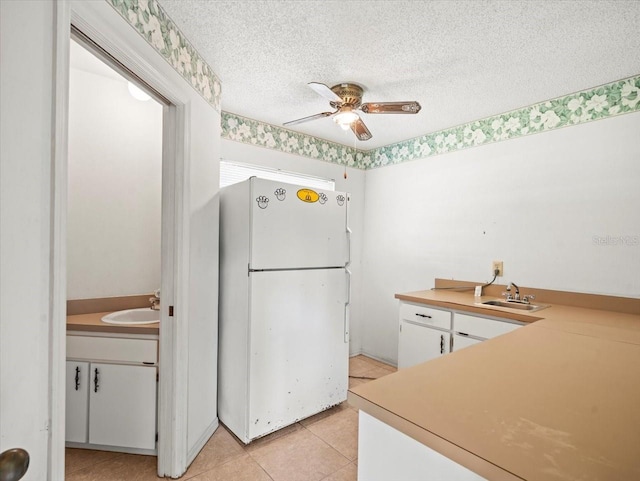 1015 Hastings Ct, Lutz, FL 33548 - kitchen featuring freestanding refrigerator, white cabinetry, a ceiling fan, light countertops, and light tile patterned flooring