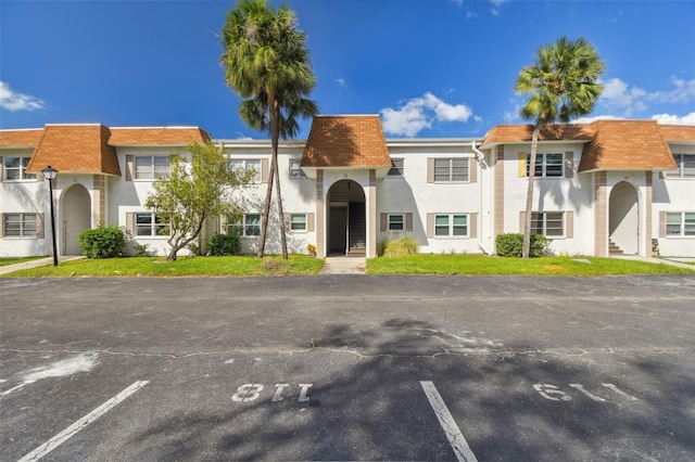 345 S Mcmullen Booth Rd Unit 142, Clearwater, FL 33759 - view of front facade featuring uncovered parking, stucco siding, and mansard roof