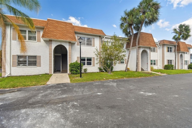 345 S Mcmullen Booth Rd Unit 142, Clearwater, FL 33759 - townhome / multi-family property with mansard roof, a shingled roof, a front lawn, and stucco siding