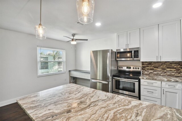 345 S Mcmullen Booth Rd Unit 142, Clearwater, FL 33759 - kitchen featuring appliances with stainless steel finishes, light stone countertops, white cabinets, decorative backsplash, and recessed lighting