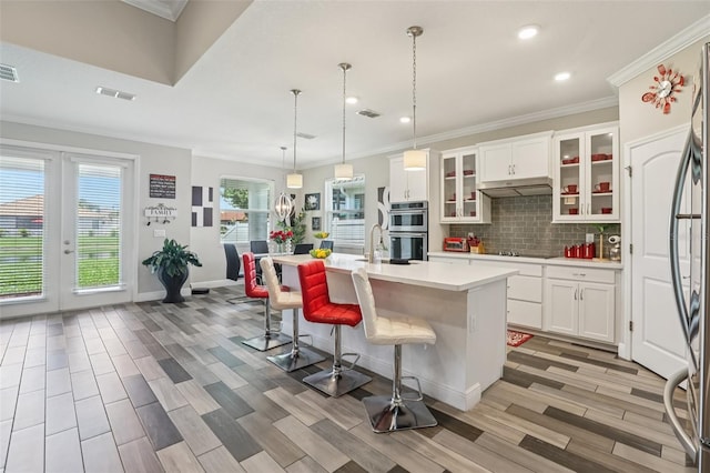 12004 Cinnamon Fern Dr, Riverview, FL 33579 - kitchen featuring stainless steel double oven, light countertops, recessed lighting, an island with sink, and light wood finished floors
