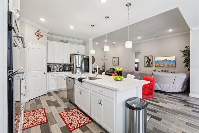 12004 Cinnamon Fern Dr, Riverview, FL 33579 - kitchen with appliances with stainless steel finishes, open floor plan, crown molding, light countertops, and light wood-style floors