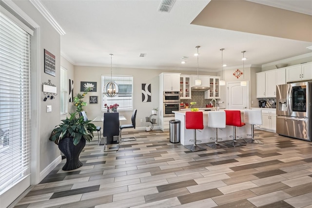12004 Cinnamon Fern Dr, Riverview, FL 33579 - kitchen featuring stainless steel appliances, decorative backsplash, a kitchen island with sink, light countertops, and white cabinetry
