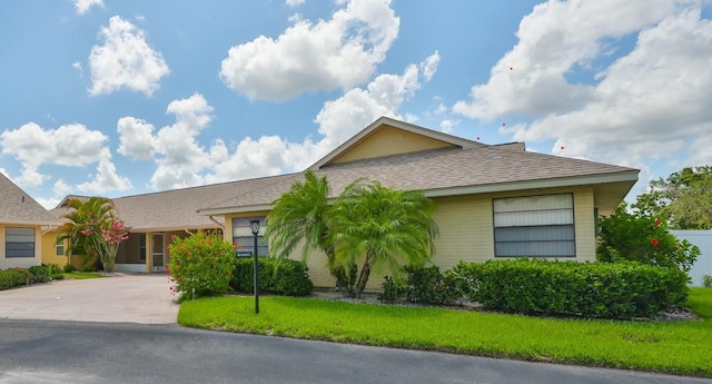 1717 Atrium Dr, Sun City Center, FL 33573 - ranch-style home featuring driveway, roof with shingles, and a front lawn
