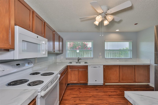 1717 Atrium Dr, Sun City Center, FL 33573 - kitchen with white appliances, dark wood-type flooring, a textured ceiling, plenty of natural light, and light stone countertops
