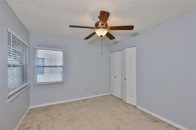 1717 Atrium Dr, Sun City Center, FL 33573 - unfurnished bedroom with carpet floors, a textured ceiling, a closet, and ceiling fan